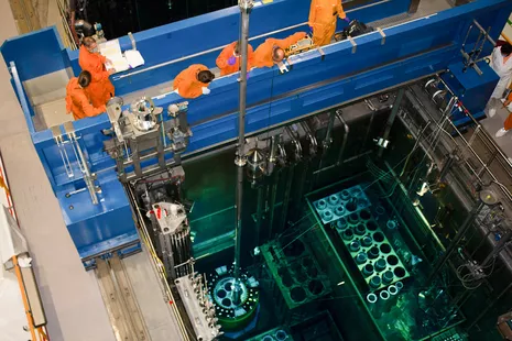 The personnel mainly control the loading from a bridge above the reactor pool. © FRM II / TUM