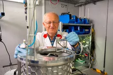 Ein Wissenschaftler positioniert den bestückten Probenhalter im Instrument.