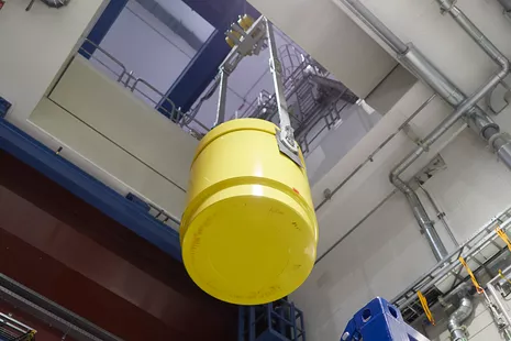 A crane, which is specially certified in accordance with the Atomic Law, maneuvers the cask through the ceiling hatch into the reactor hall on the upper floor. © Bernhard Ludewig, FRM II / TUM